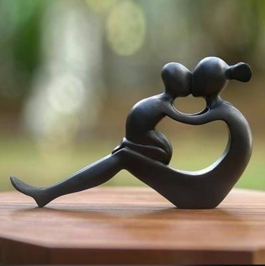 Smooth abstract ebony sculpture of two figures leaning together and kissing