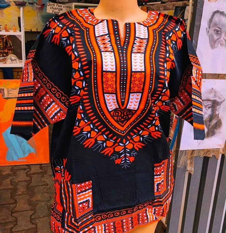 Black and orange dashiki top with traditional print, displayed on a mannequin