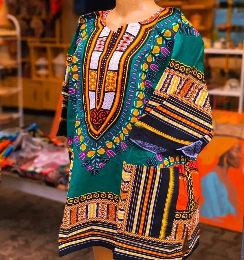 Green dashiki top with orange, yellow and pink traditional print on a mannequin