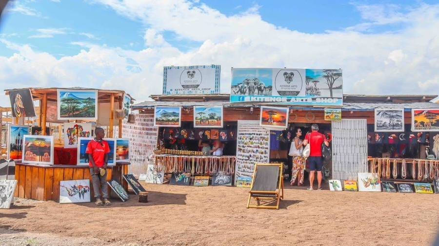 Wide view of the Kitenge Arts shop front at Chemka Hot Springs with paintings, beadwork and jewellery on display