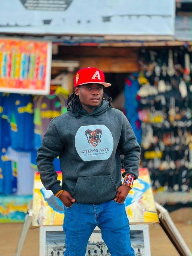 Omary Kitenge Juma standing outside the Kitenge Arts shop at Chemka Hot Springs
