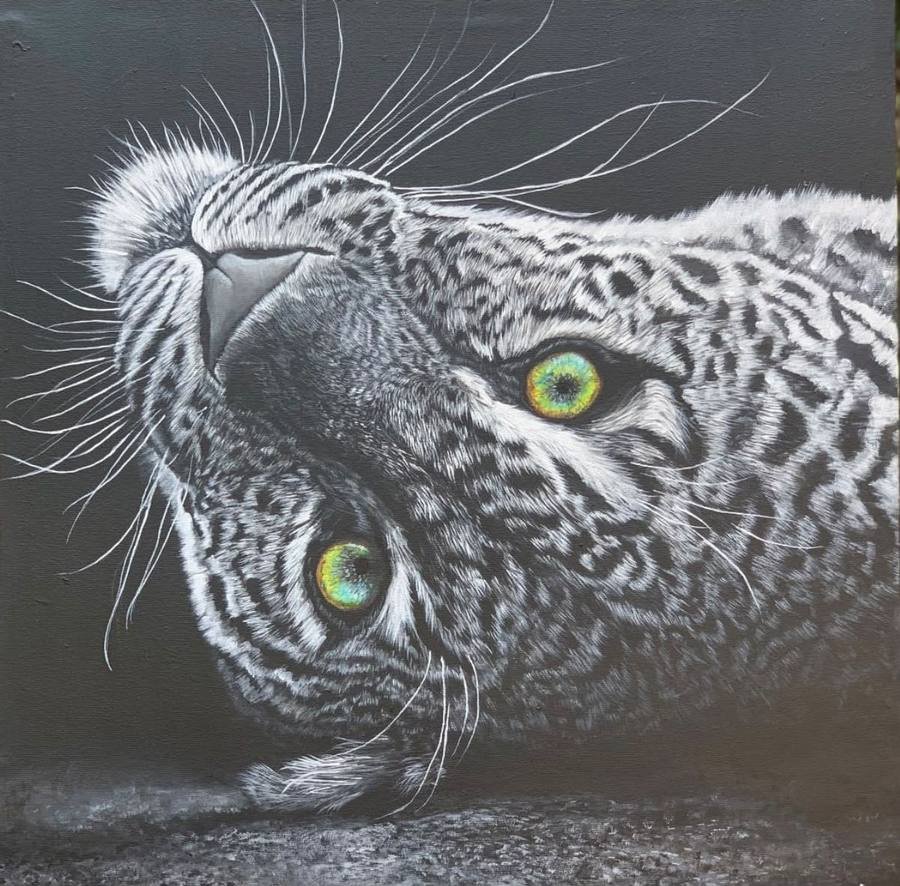 Acrylic painting of a leopard lying on its side with vivid green eyes